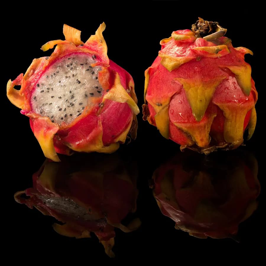 Dragon fruit halved to show the speckled white flesh