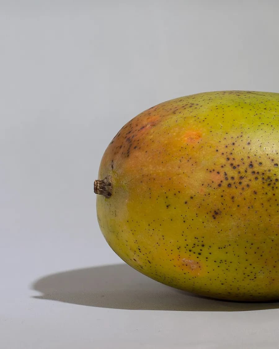 A ripe blushing mango against a plain backdrop